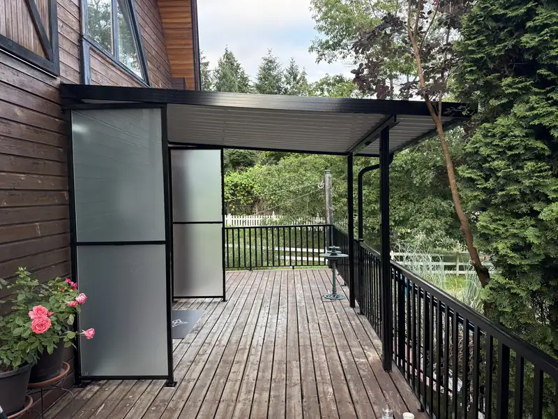 Aluminum patio cover with frosted privacy screens over a wood deck